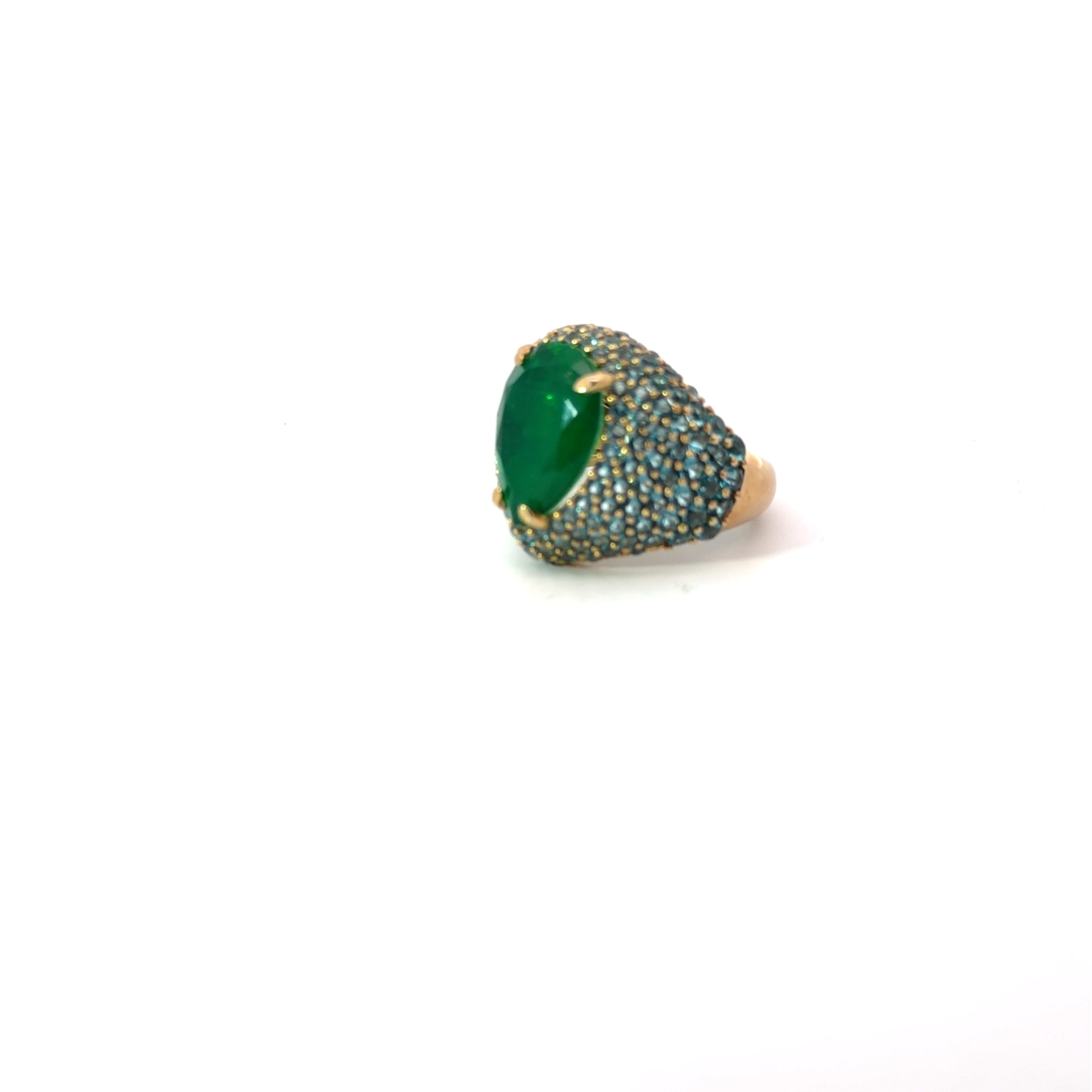 ANNA statement ring, emerald green pear-shaped center stone with Paraiba blue pavé zirconias, viewed from the side.