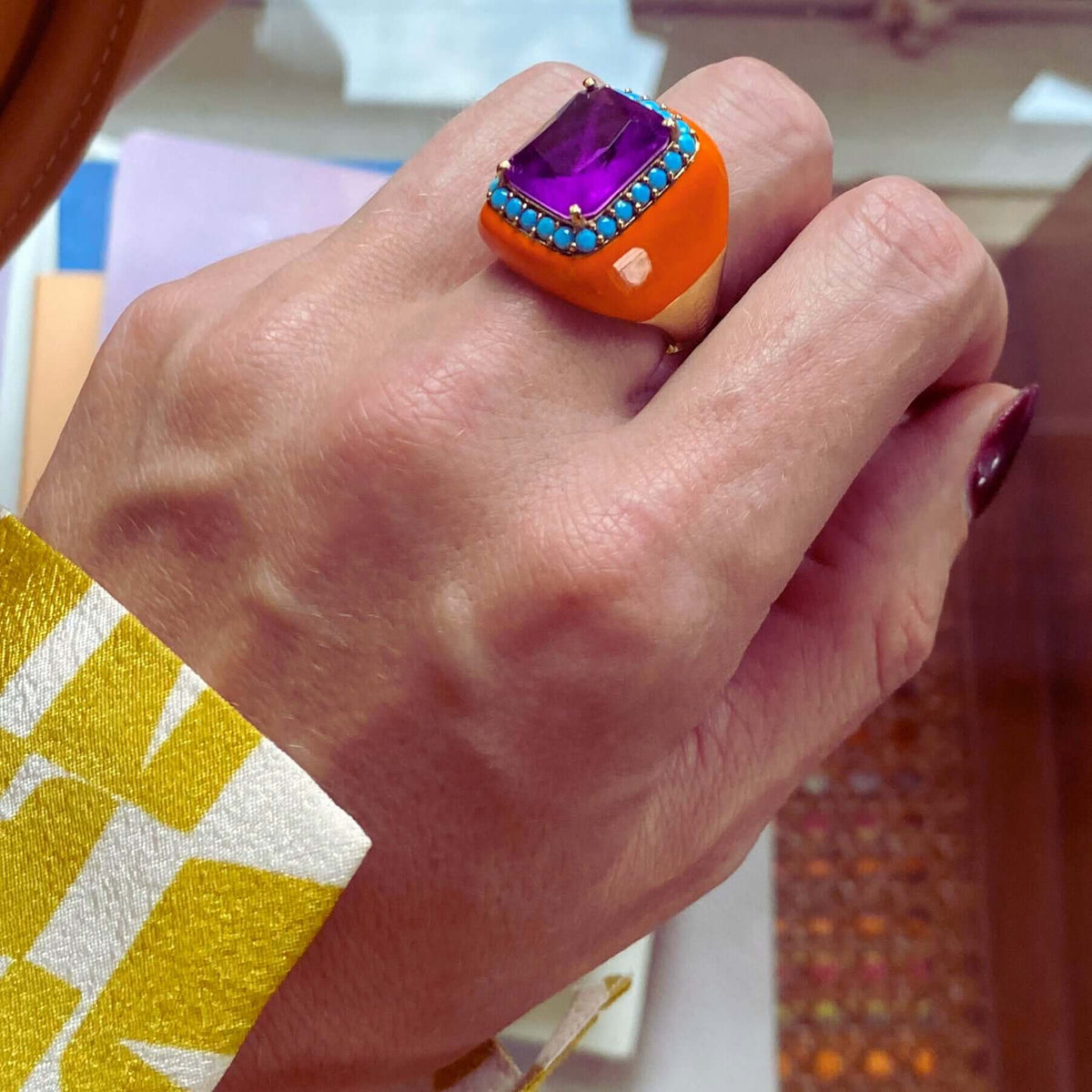 MAXIMA statement ring, orange enamel band with amethyst purple center stone and turquoise zirconia halo, worn on hand. GIADAN for Le.Paul Jewelgarden