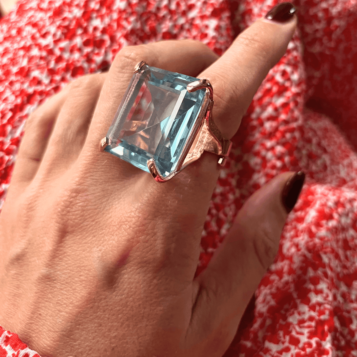 On-hand view of NARCISA - LIGHT AQUAMARINE BLUE by Giadan, rose gold plated statement ring with large aquamarine blue zirconia in open frame