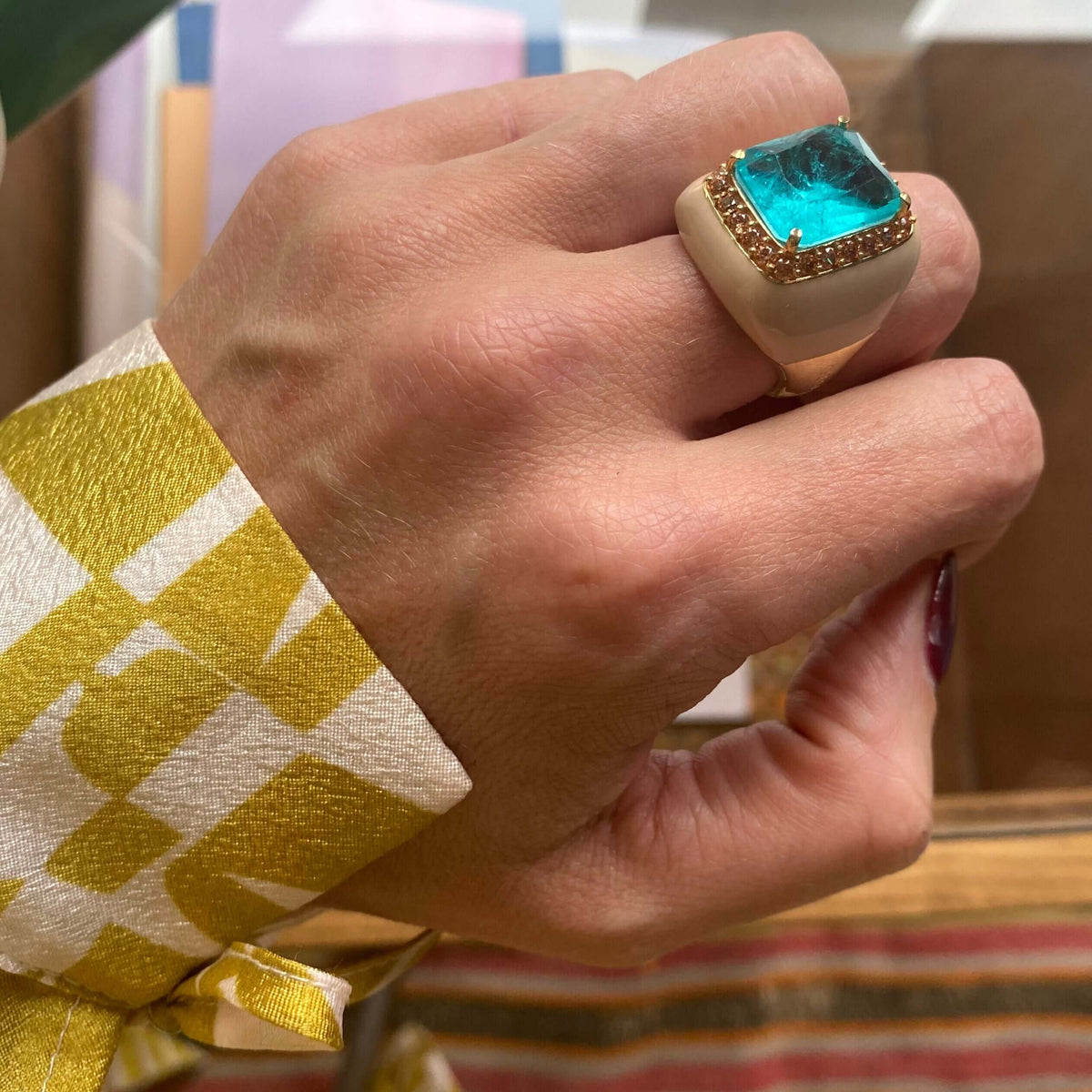 SUZETTE statement ring, large aquamarine blue center stone with champagne pavé halo and taupe enamel band, worn on hand. GIADAN for Le.Paul Jewelgarden
