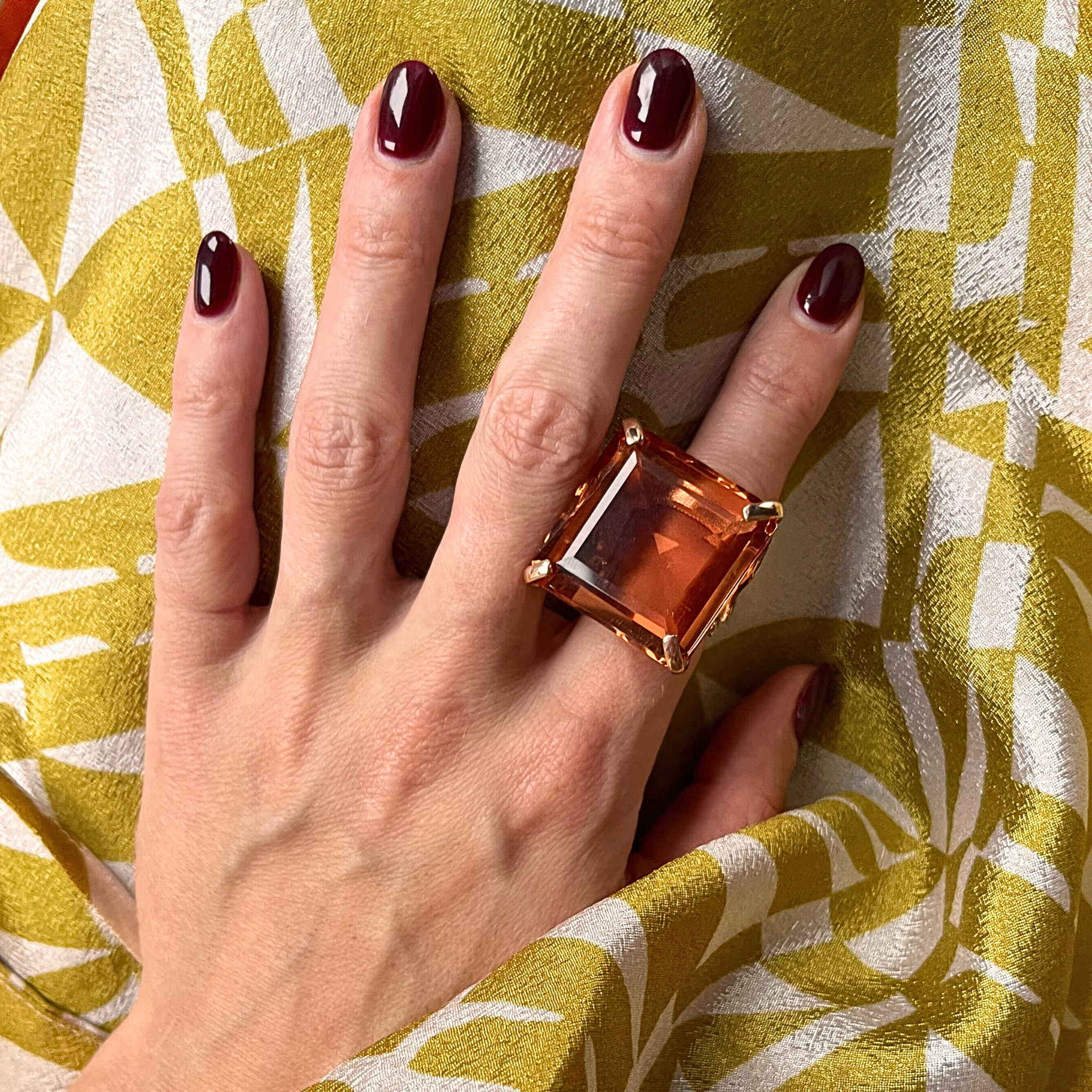 A person's hand displaying a rose gold plated ring with a large deep topaz yellow zirconia center stone - NARCISA DEEP YELLOW by Giadan for Le.Paul Jewelgarden.