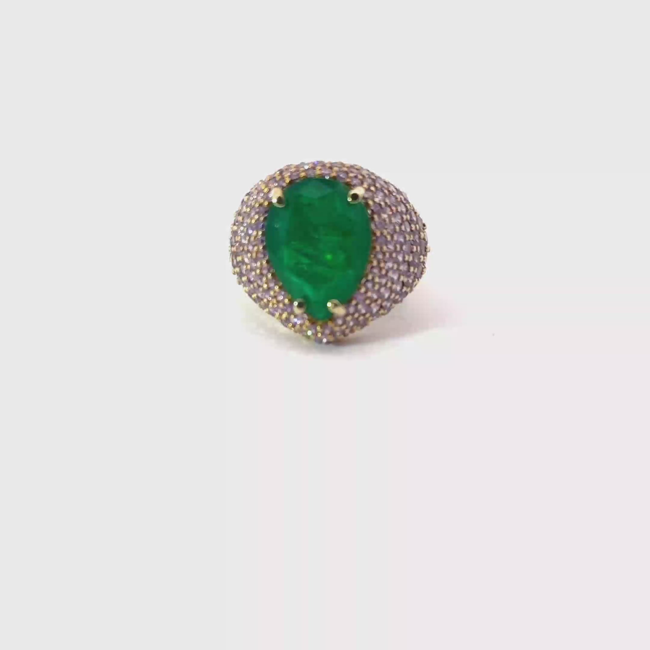 ELISABETH, 360 video: ELISABETH statement ring, 360 degree rotating view, emerald green pear-shaped center stone with violet pavé zirconias, yellow gold plated. Giadan for Le.Paul Jewelgarden.